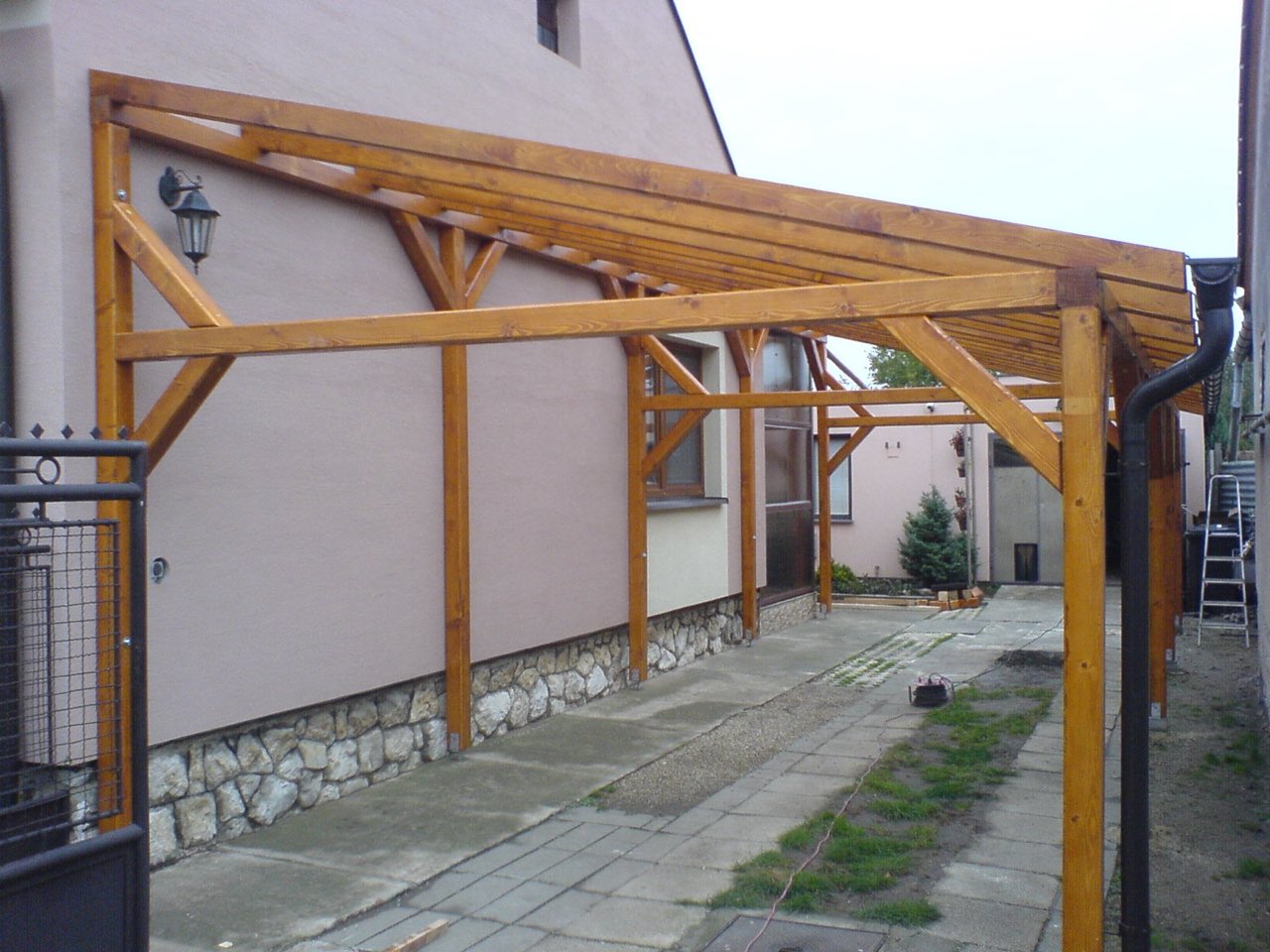 Drevený prístrešok pri rodinnom dome
